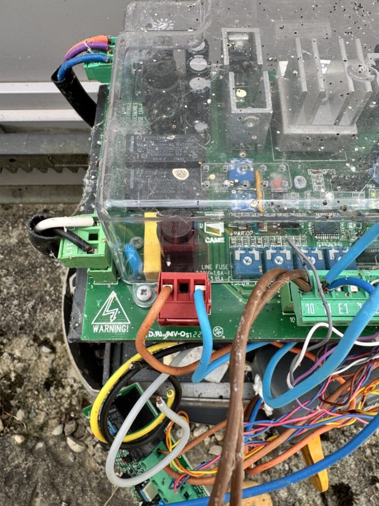 Platine électronique CAME poussiéreuse avec fils multicolores et connecteur rouge. Texte: WARNING!, LINE FUSE 1.6A-F, 3.15A-L.